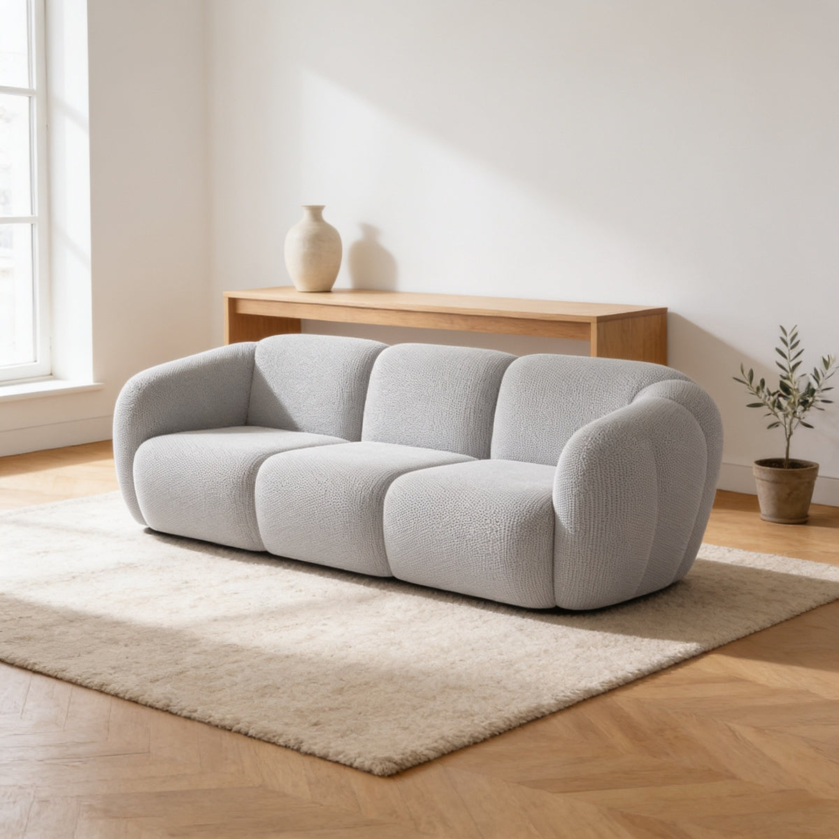 Light grey three-seat bubble sofa, two hundred and forty centimetres wide, on an oatmeal rug in a warm living room.