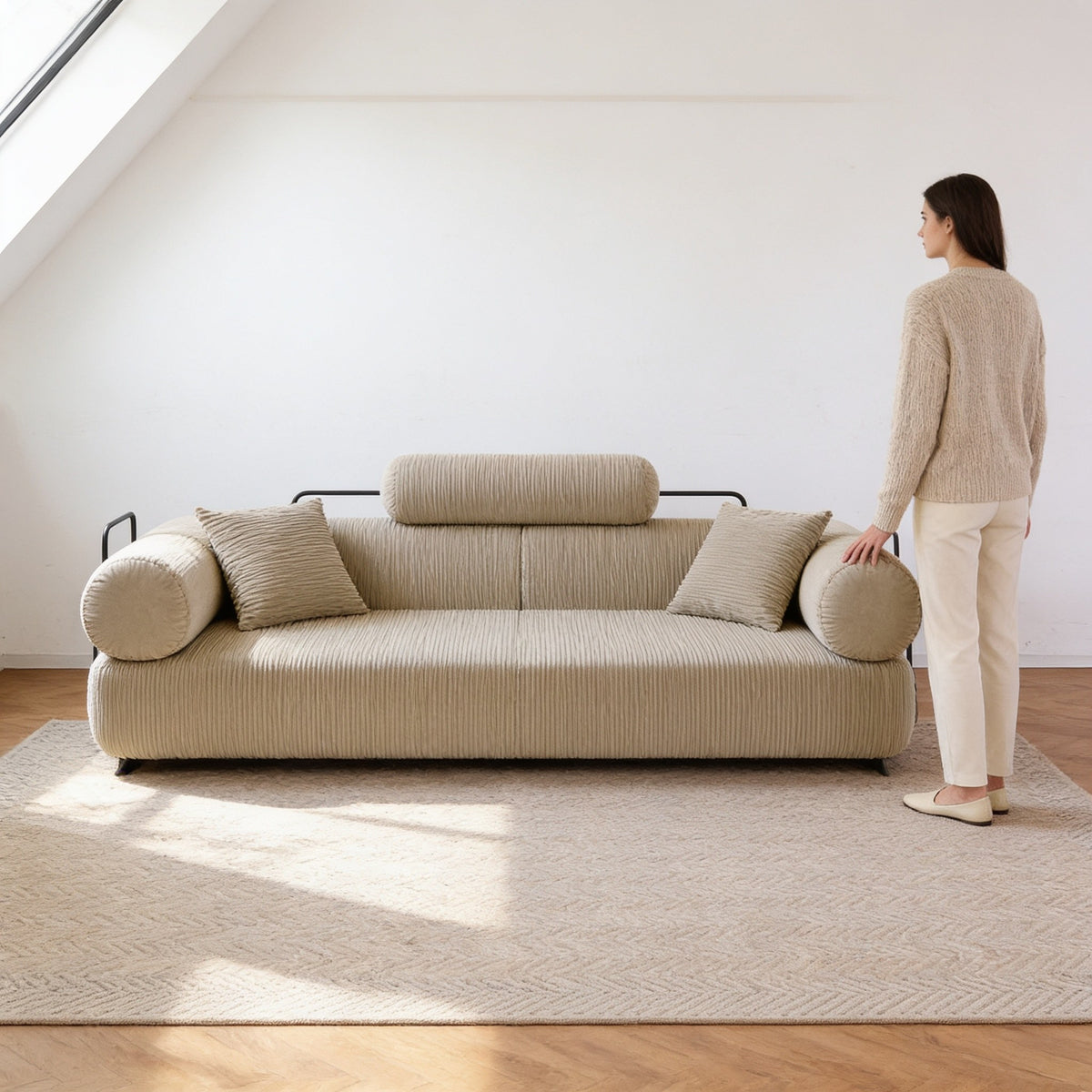 Adult standing beside the two hundred centimetre wide folding sofa bed, its rounded arm reaching only to mid-thigh.
