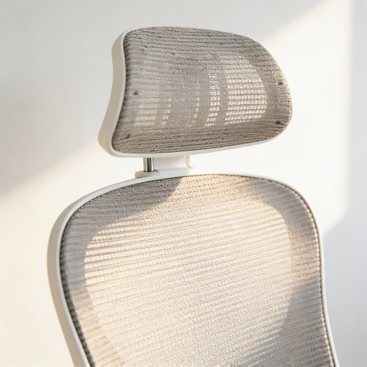 Close detail of the breathable mesh backrest and adjustable mesh headrest.