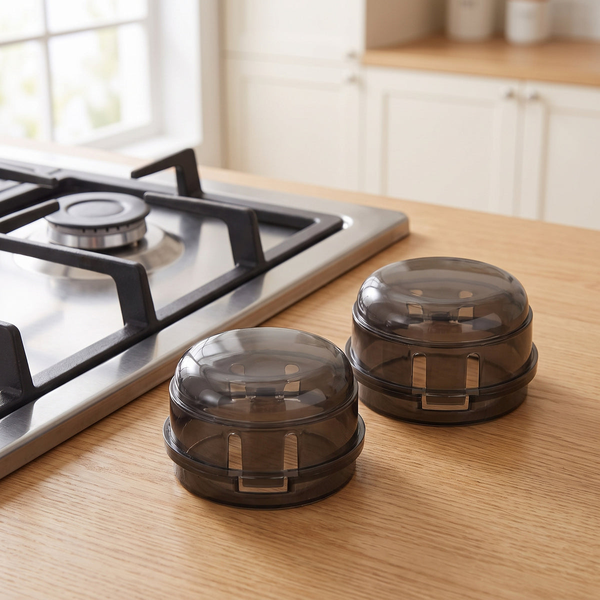 Two smoke-black stove knob covers on a light oak kitchen countertop