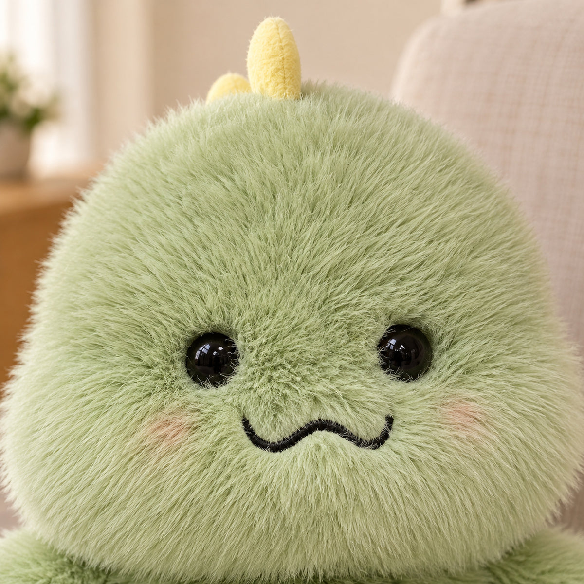 Close-up of green long-pile plush fur, black eyes and embroidered wavy mouth