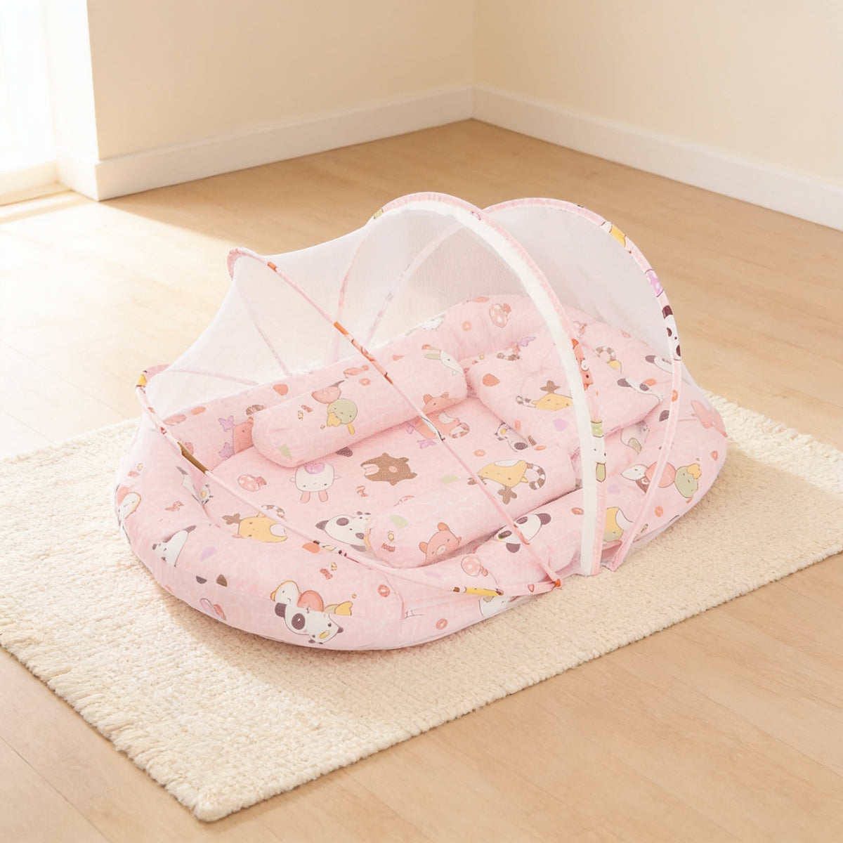Pink Animals foldable travel bassinet, pale pink cotton with cartoon animals, with its mesh net dome up on a cream rug in a bright living room