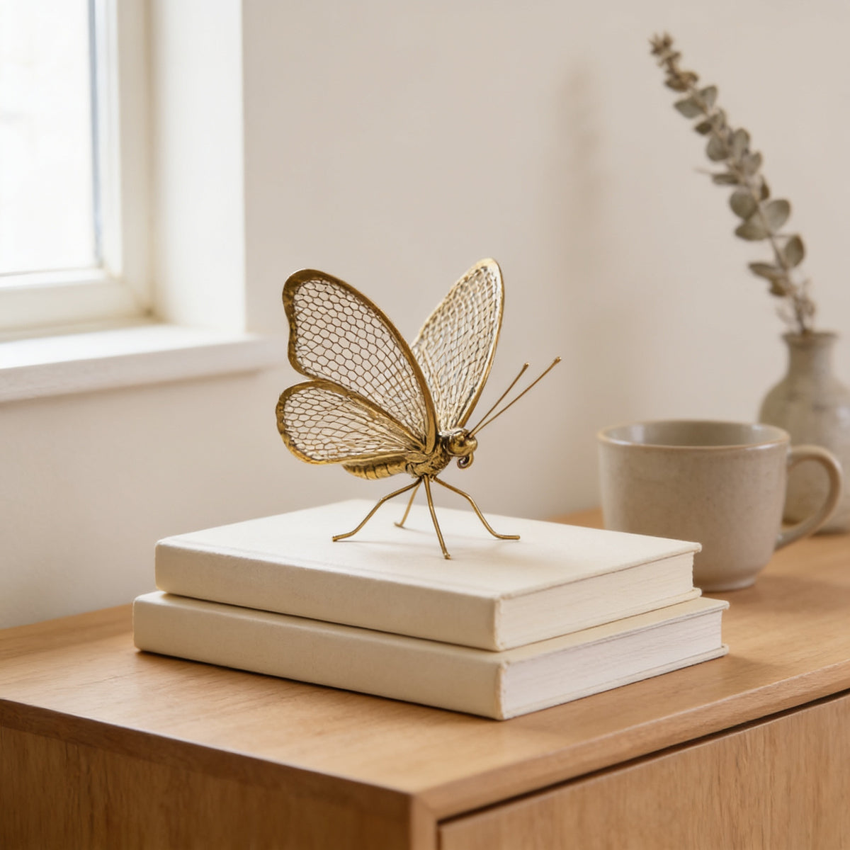 Gold metal butterfly figurine on a stack of books on an oak console — Gold Metal Insect Figurine, Ant or Butterfly