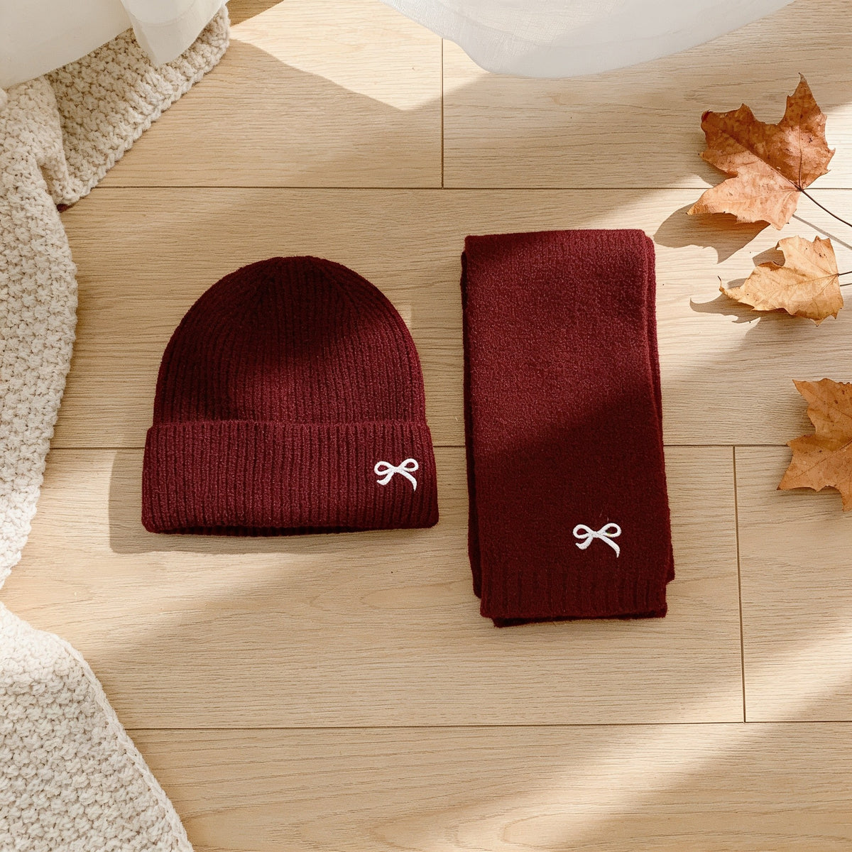 Burgundy ribbed knit kids hat and scarf set with embroidered bows.
