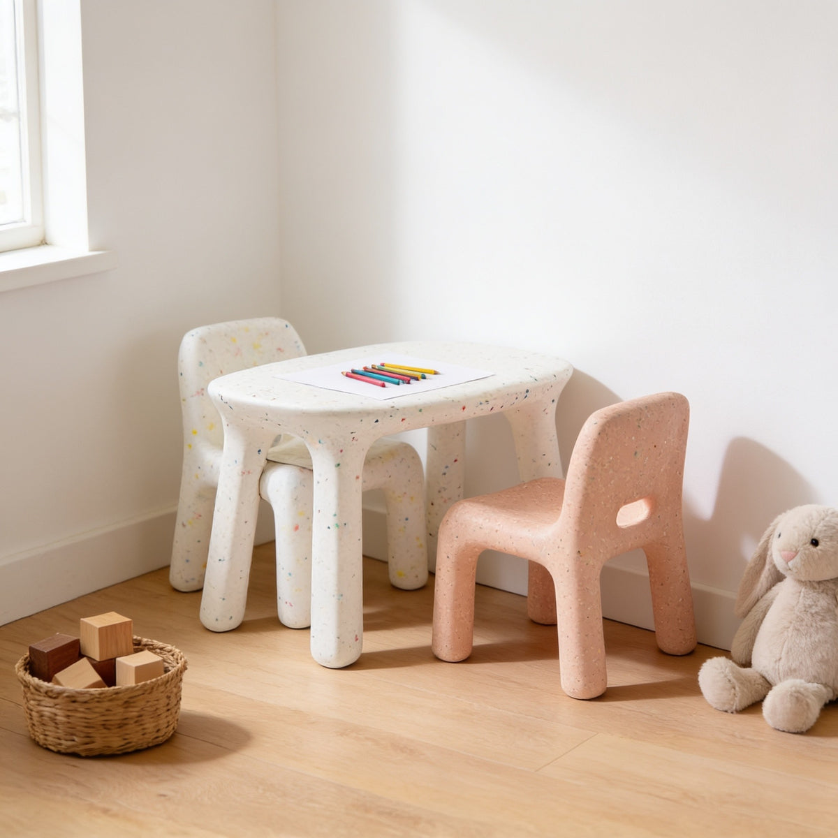 White speckled kids table with white & dusty pink speckled chairs in a sunny kids room.