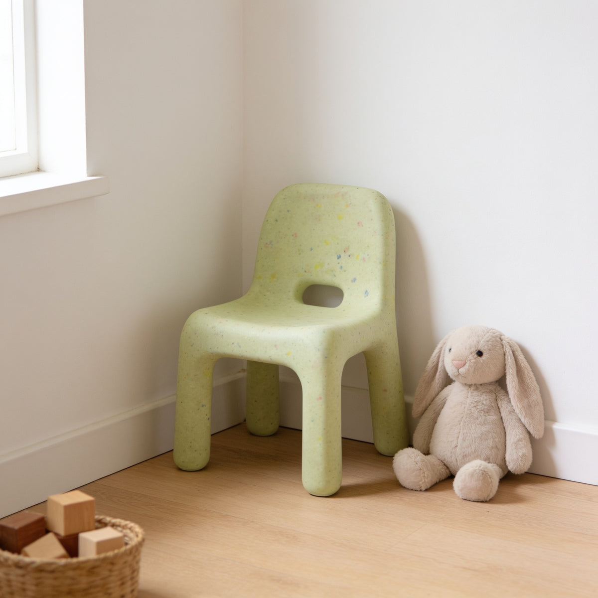 Matcha Green speckled molded kids chair with a hand-hole backrest in a sunny kids room.