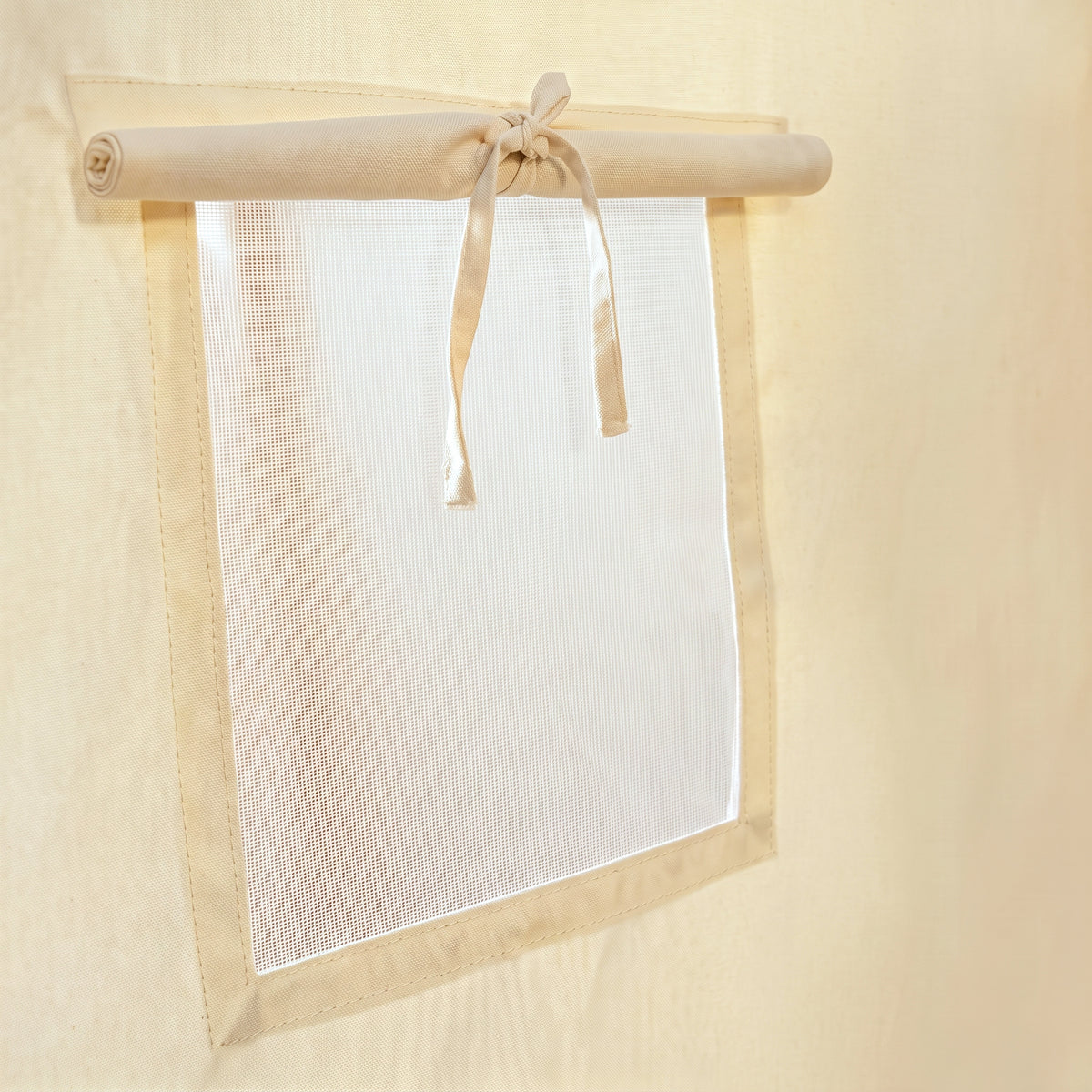 Close-up of the play tent's roll-up window shade on its bar with a single fabric tie