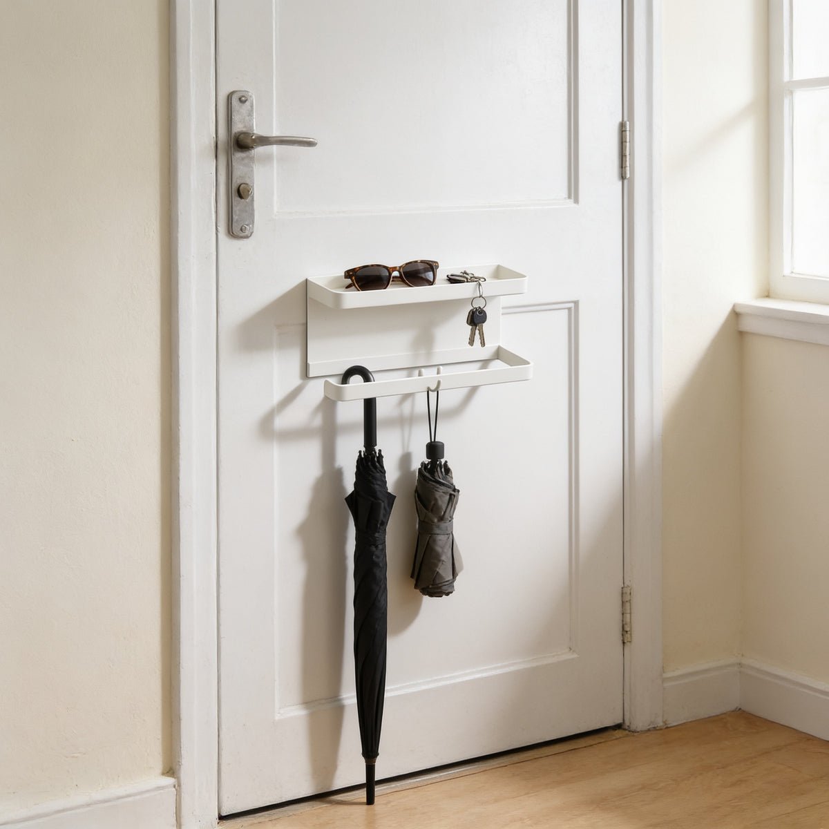 White magnetic umbrella and key holder with tray on a front door