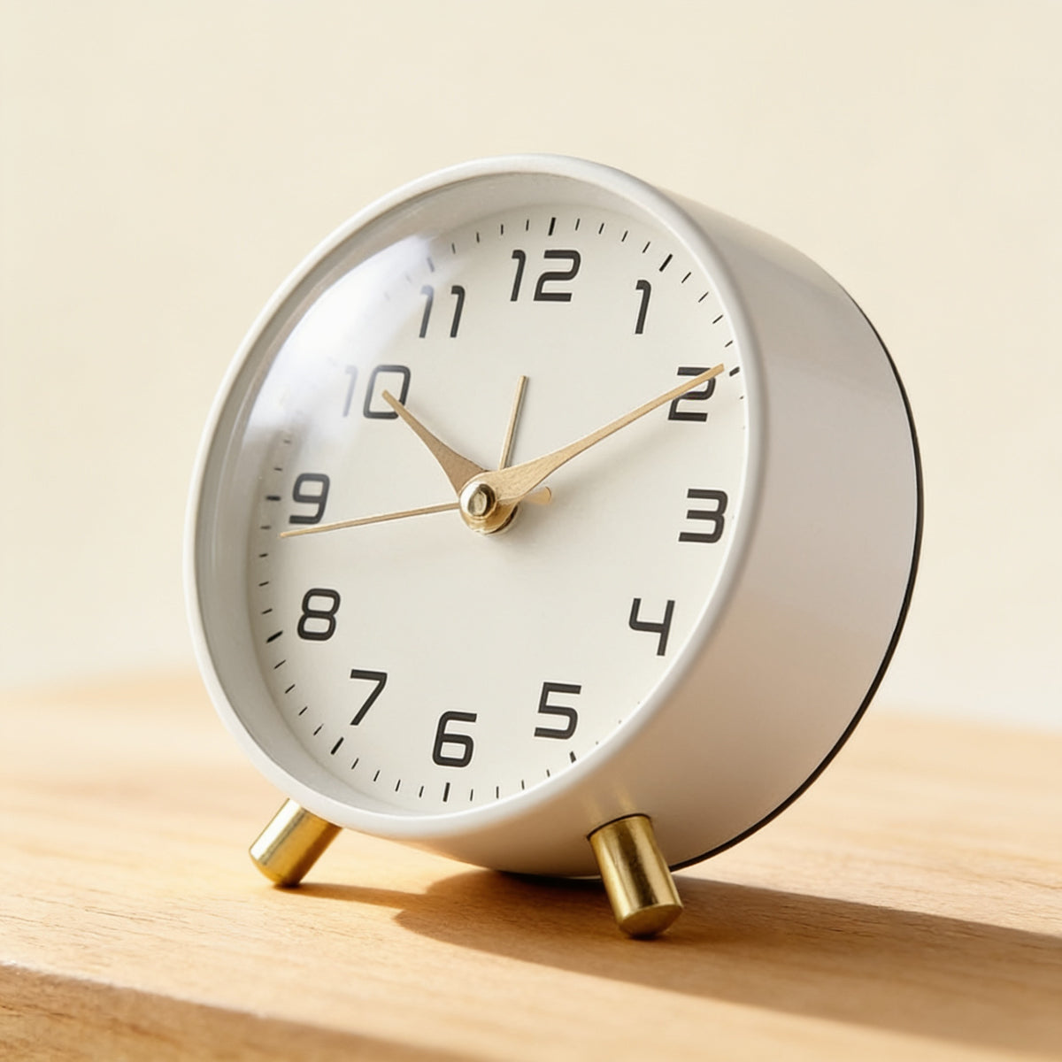 Close-up of the brass feet and dial of the silent analog alarm clock