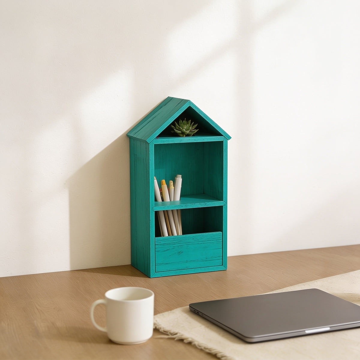 Medium teal-blue house-shaped desk shelf on a home-office desk.