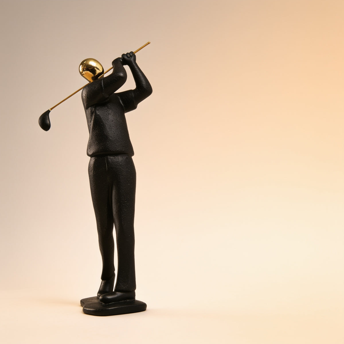 Golfer full swing pose, black and gold resin figurine on cream background — Black & Gold Sports Figurine