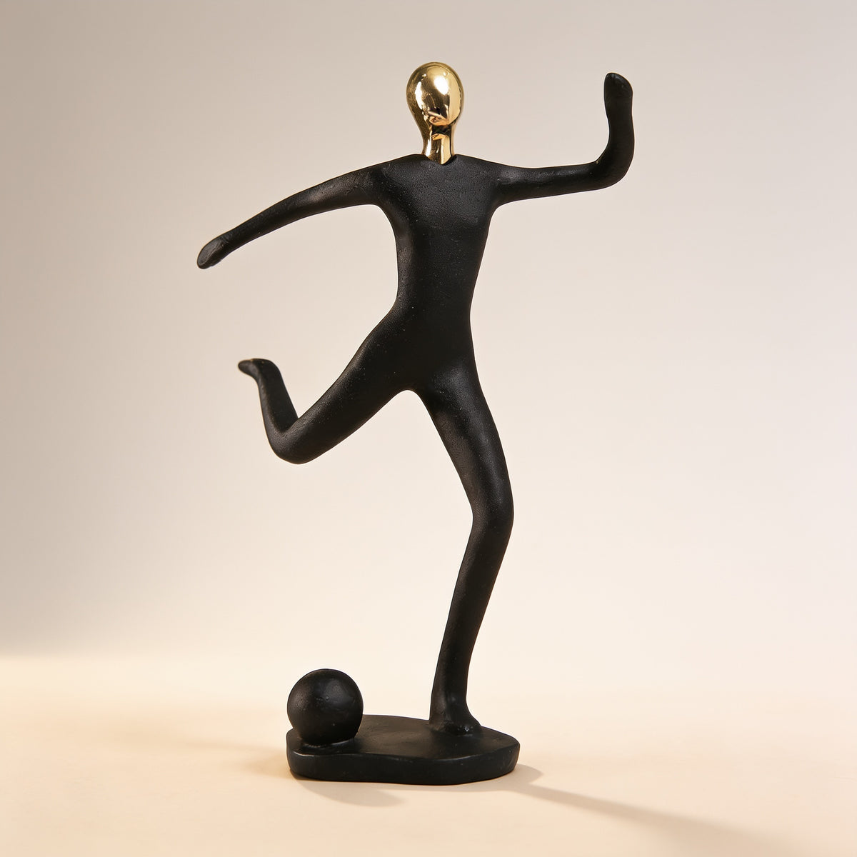 Soccer player pose, black and gold resin figurine on cream background — Black & Gold Sports Figurine