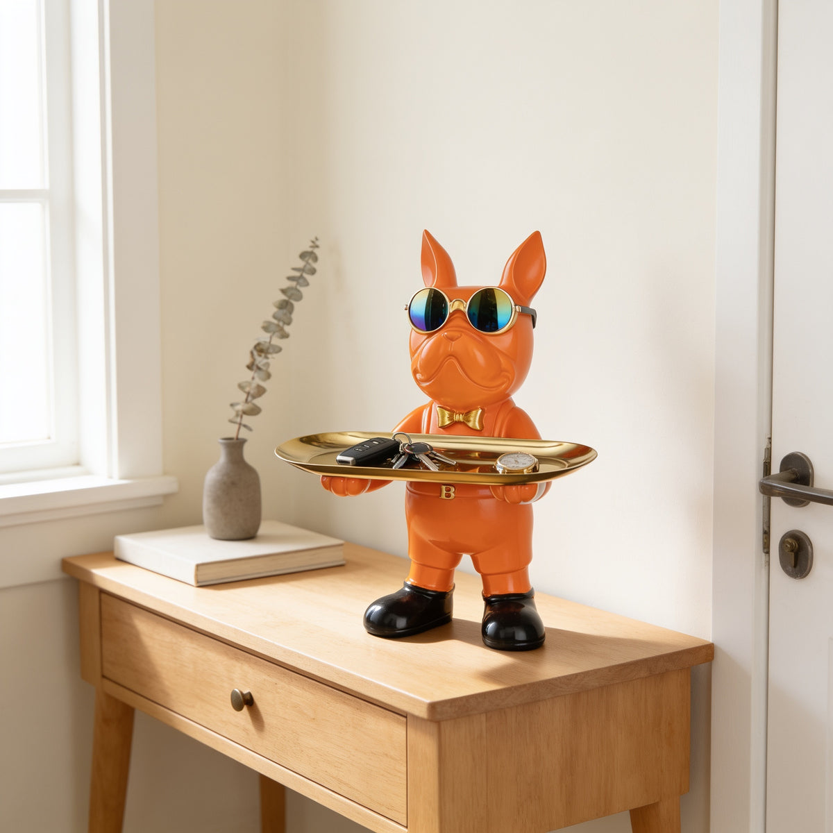 Orange standing French bulldog butler statue holding a tray on an entryway console
