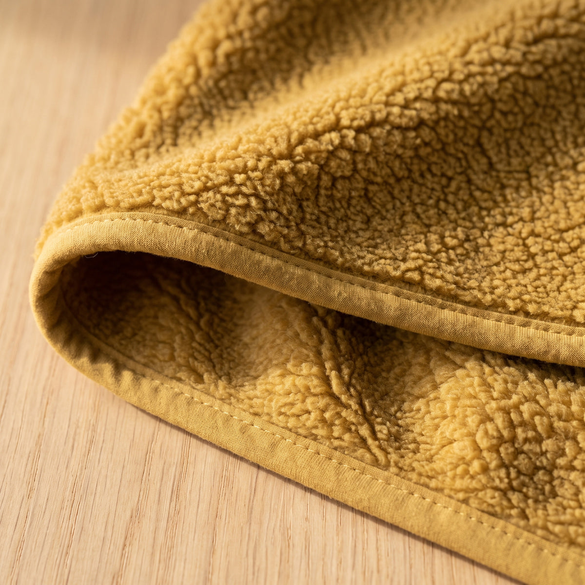 Hem of the fleece jacket turned back showing the same deep pile on both faces