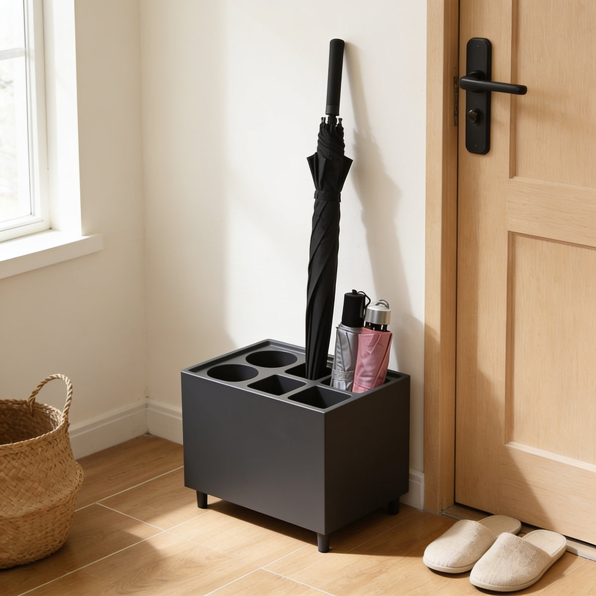 Charcoal six-slot umbrella stand with drip tray by a front door
