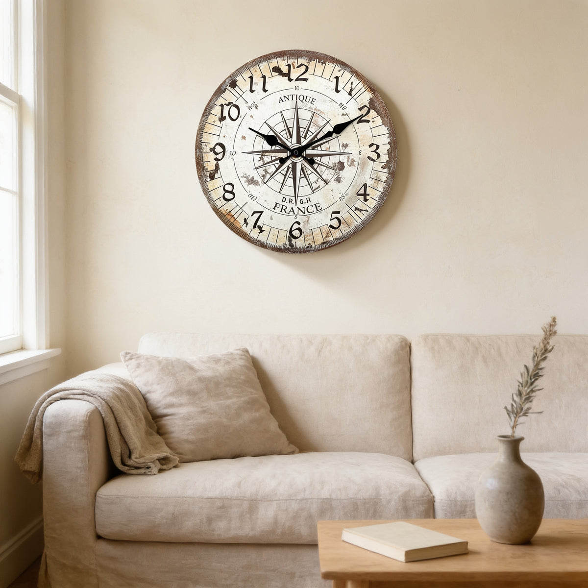 Vintage compass wall clock above a cream sofa in a sunlit living room