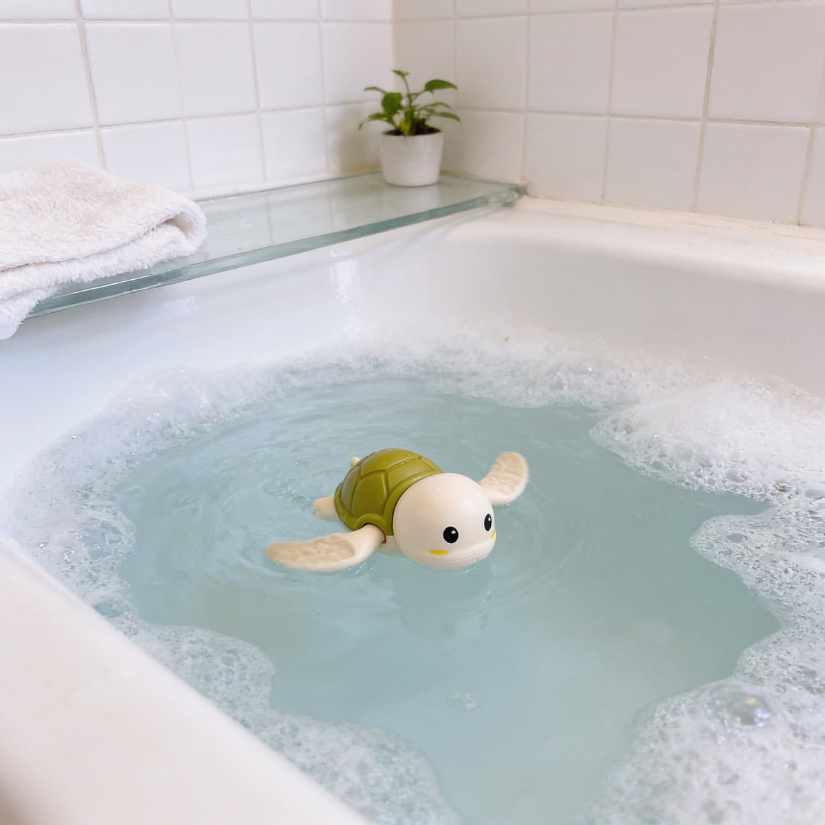 Wind-Up Tortoise, Green toddler bath toy in a bright bathtub.