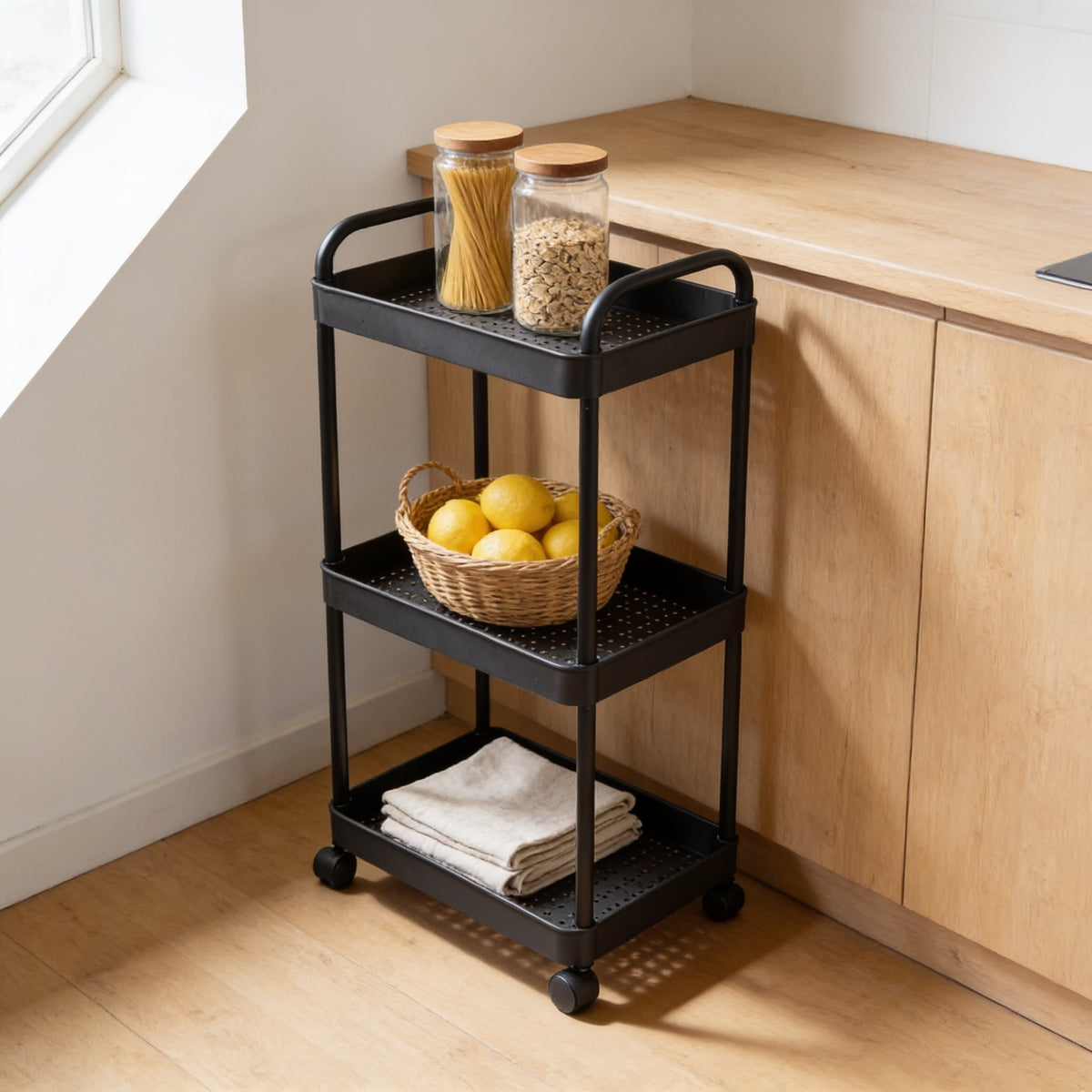 Black three-tier rolling utility cart in a kitchen corner.