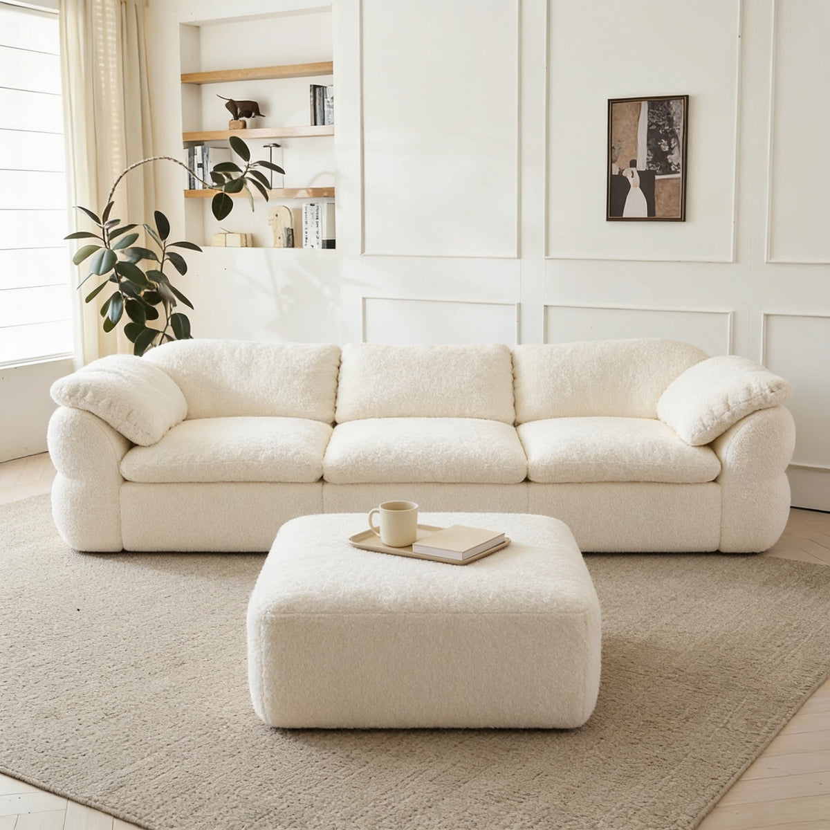 Cream chenille modular cloud couch arranged as a three-seat sofa with its square ottoman in front, in a bright living room.
