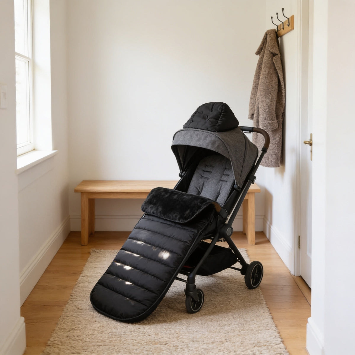 Black quilted fleece-lined bunting bag fitted in an empty pushchair in a warm hallway.
