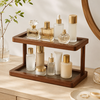 2-tier walnut bamboo countertop shelf displaying perfume and skincare bottles on a wood dresser
