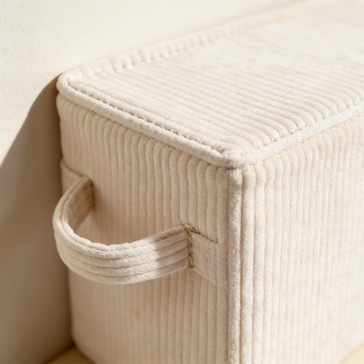 Close detail of the cream corduroy ribs and stitched handle join.
