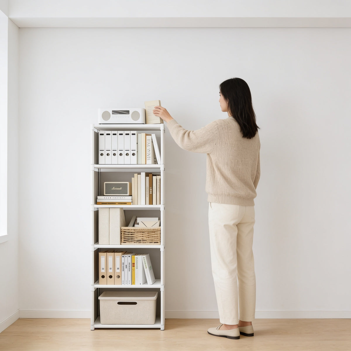 Adult placing a book on the 155 cm bookshelf, whose top reaches her chin.