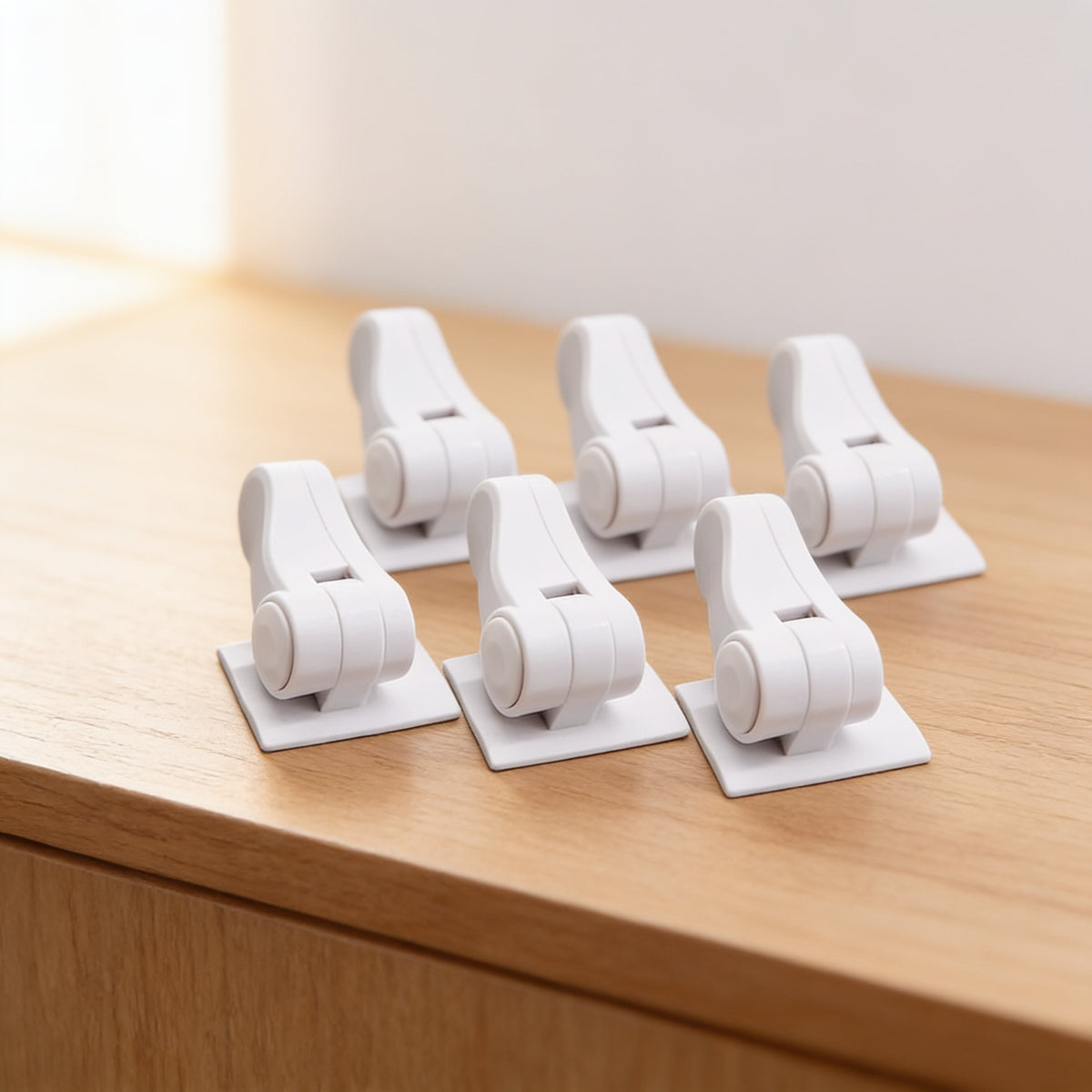 6-Pack of white adhesive door lever locks in two rows on a light oak surface