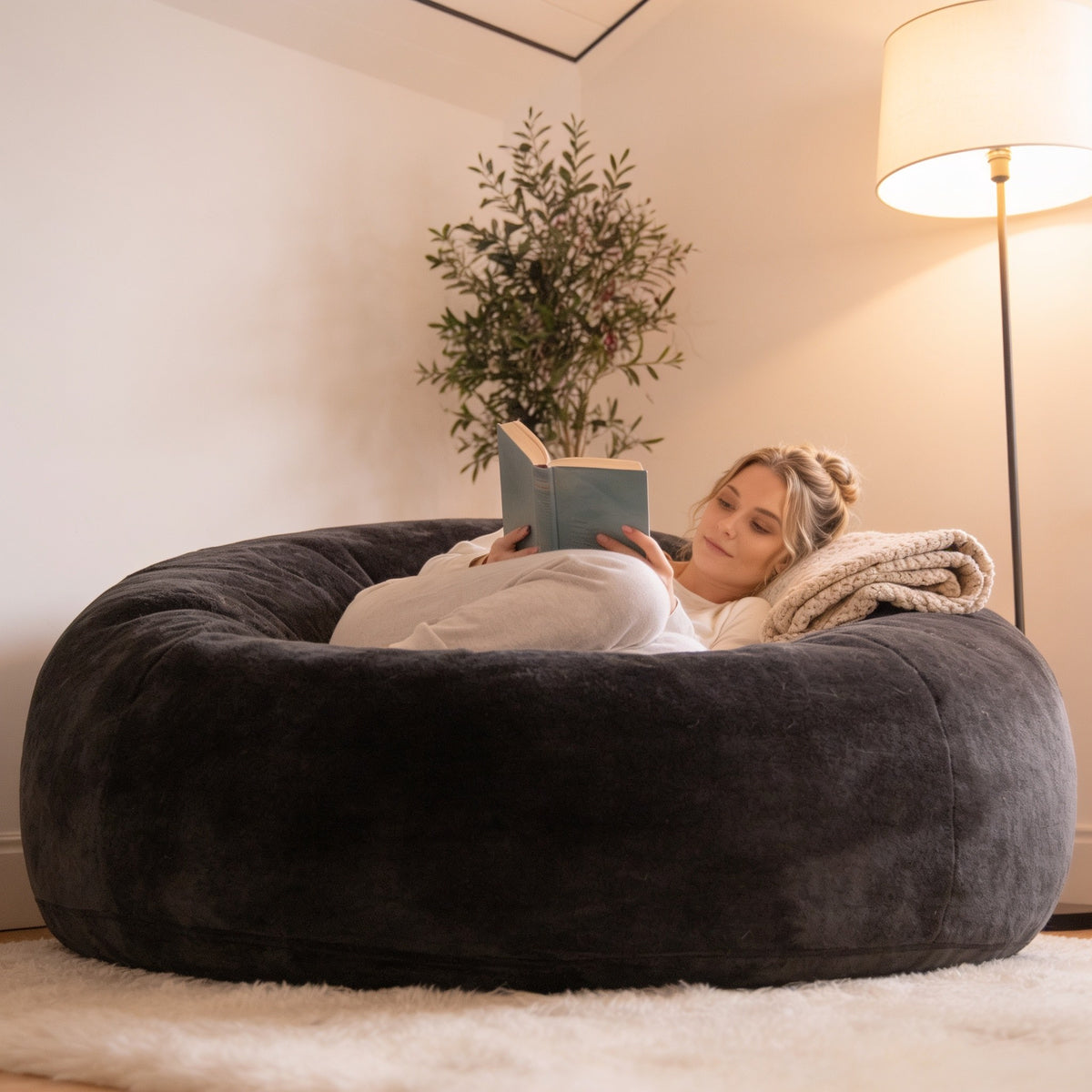 Dark gray 4 ft plush foam bean bag chair in a living room corner.