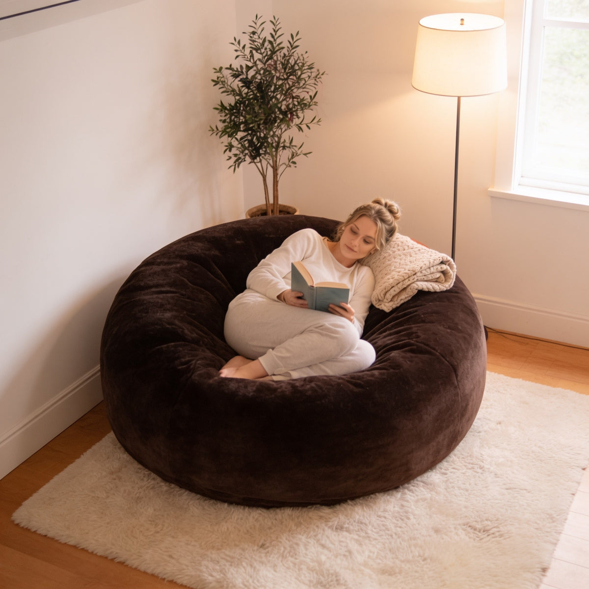 Brown 4 ft plush foam bean bag chair in a living room corner.