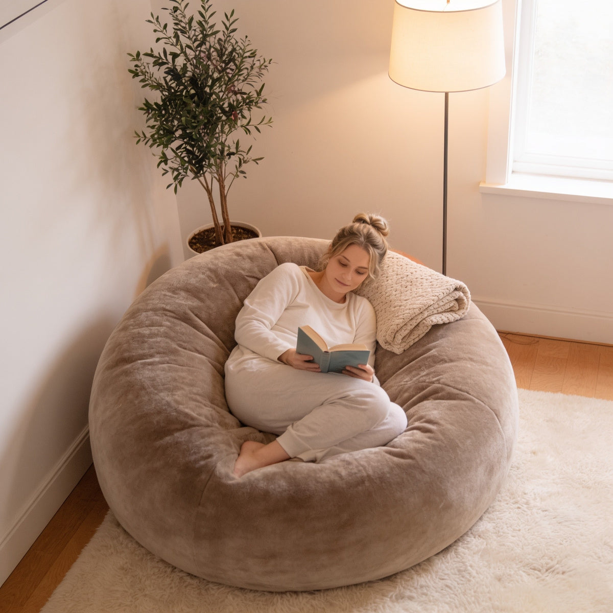 Beige 4 ft plush foam bean bag chair in a living room corner.