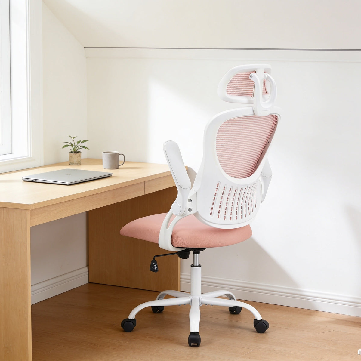 Pink mesh office chair with white frame and headrest at a home office desk.