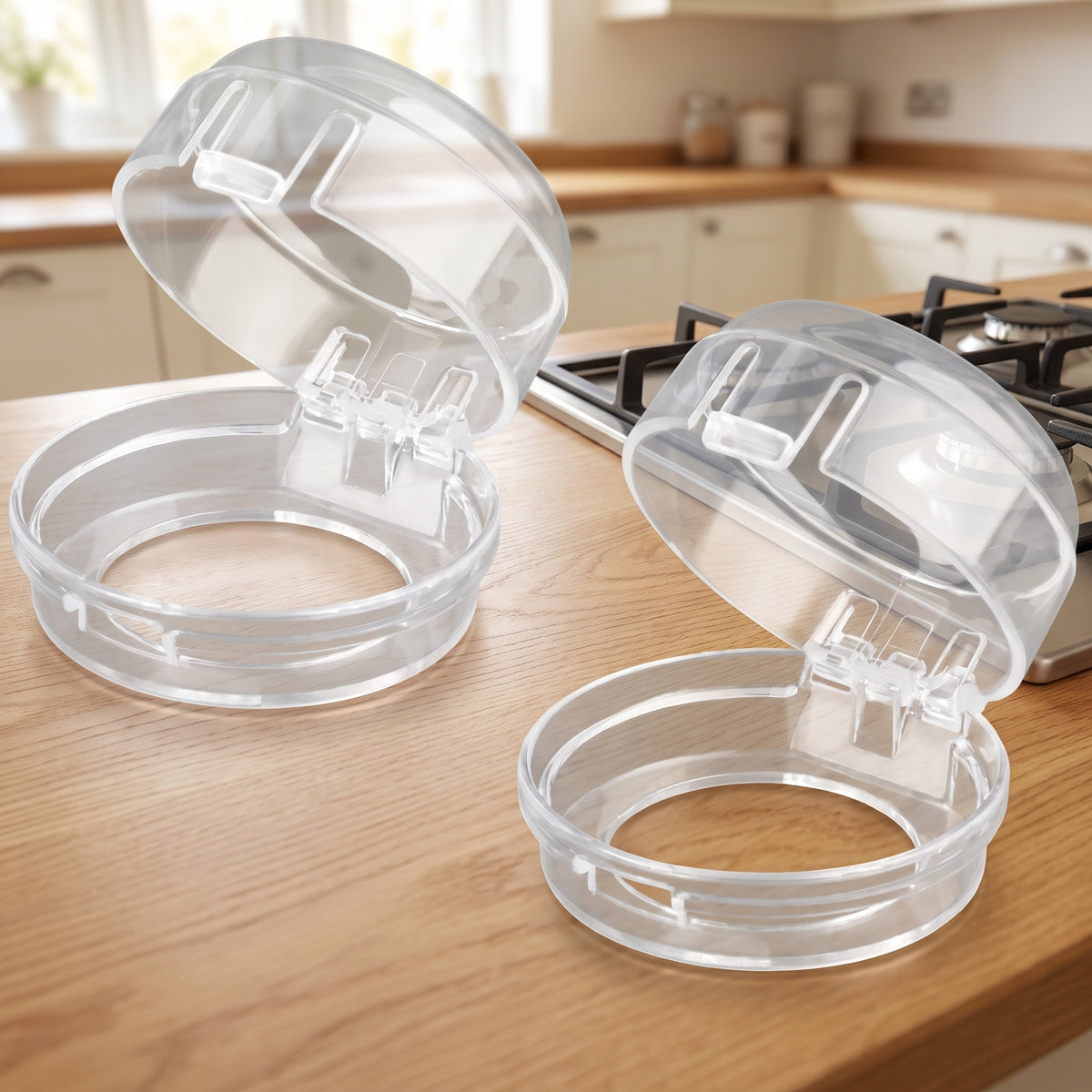 Two clear stove knob covers on a light oak kitchen countertop