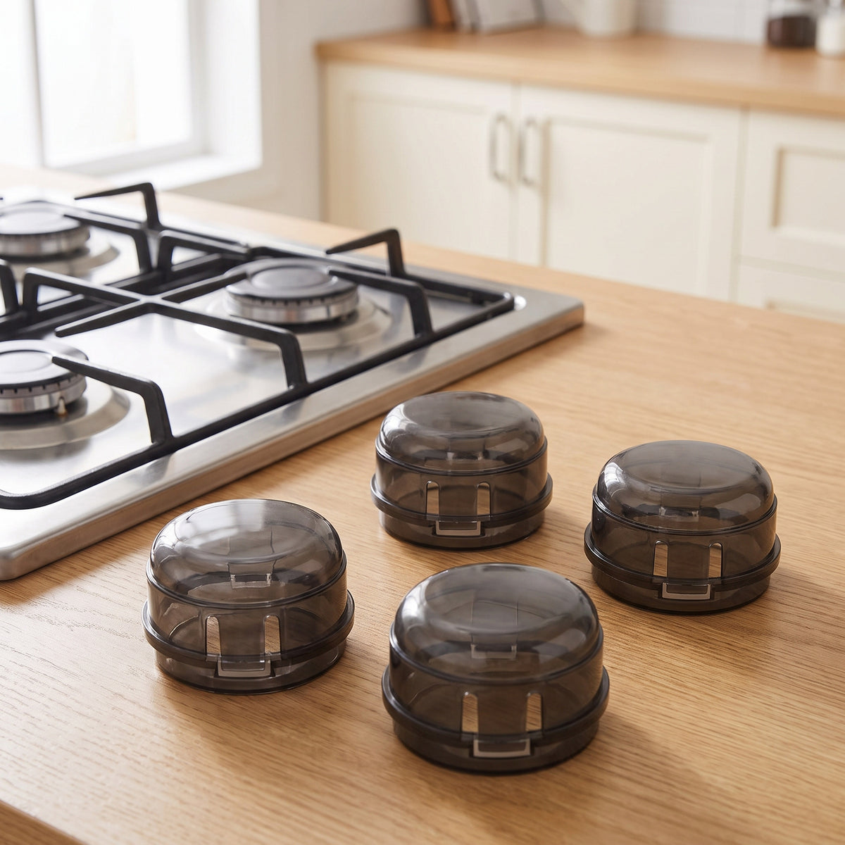 Four smoke-black stove knob covers on a light oak kitchen countertop