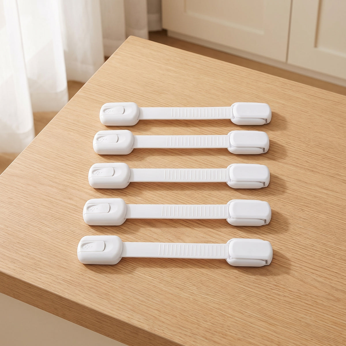 Five white strap cabinet locks on a light oak kitchen countertop