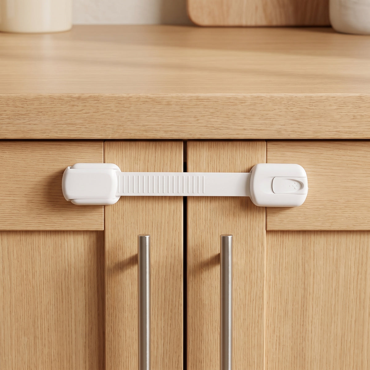 White strap cabinet lock fitted across two light oak kitchen cabinet doors