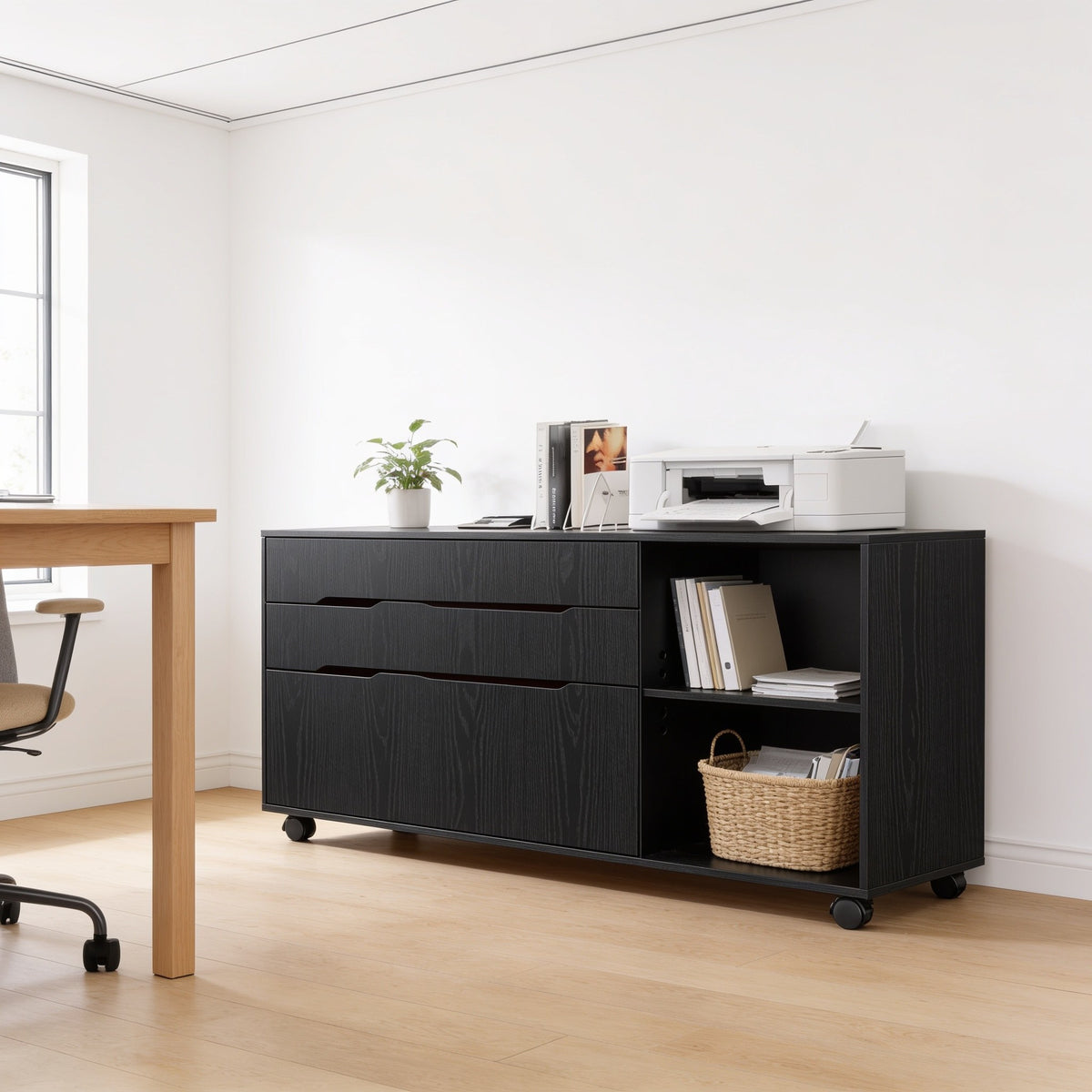 Black mobile file cabinet with three drawers and open shelf beside a desk.