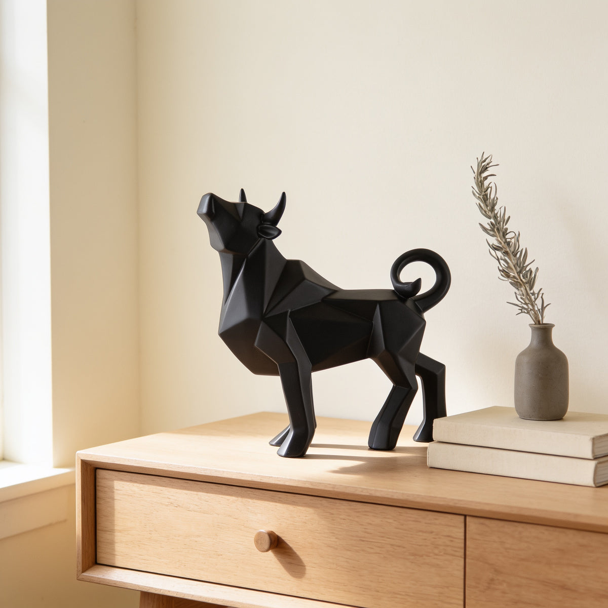 Black faceted bull statue, standing pose, on an oak console — Faceted Geometric Bull Statue