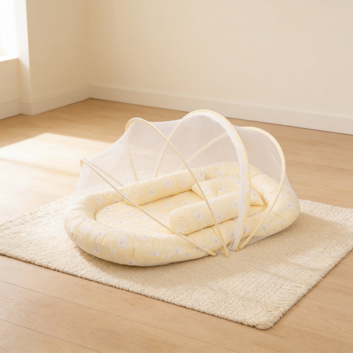 Butter Stars foldable travel bassinet, soft butter-yellow cotton, with its mesh net dome up on a cream rug in a bright living room