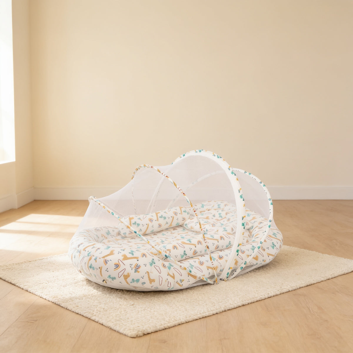 Cream Giraffes foldable travel bassinet, cream cotton with small giraffes and rainbows, with its mesh net dome up on a cream rug in a bright living room