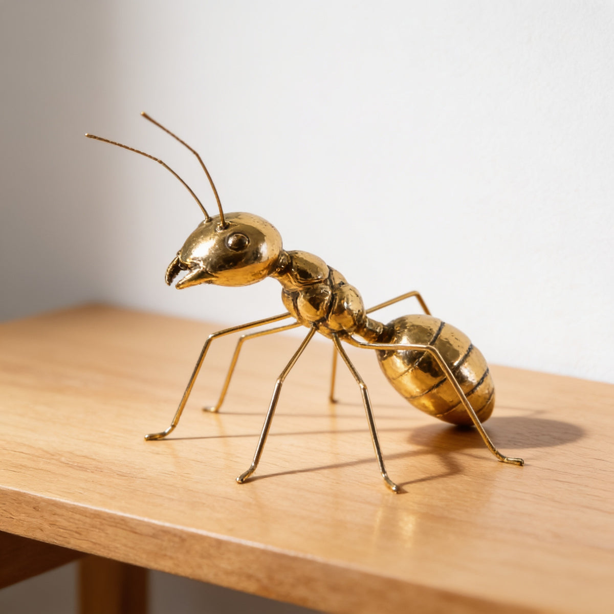 Gold metal ant figurine standing on its wire legs on oak — Gold Metal Insect Figurine, Ant or Butterfly