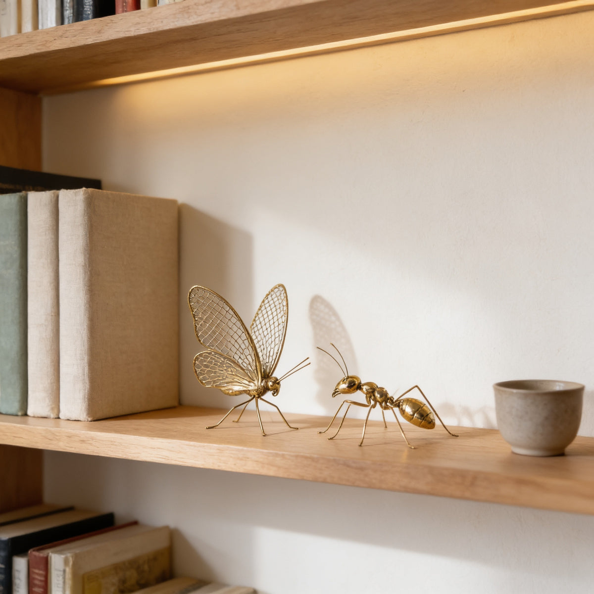 Gold ant and butterfly figurines together on an oak bookshelf with books for scale — Gold Metal Insect Figurine, Ant or Butterfly