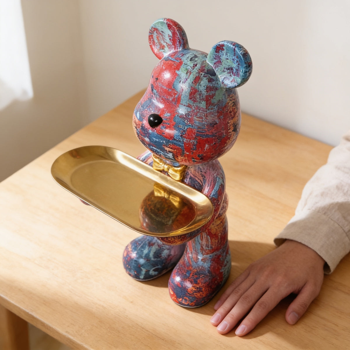 Hand beside the graffiti bear statue showing its size