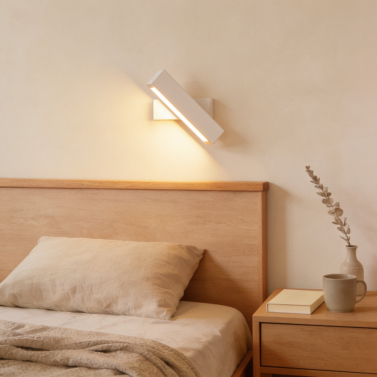 Small beech swivel wall sconce, white bracket, warm white light, above an oak headboard — Hardwired Solid Wood Swivel Wall Sconce