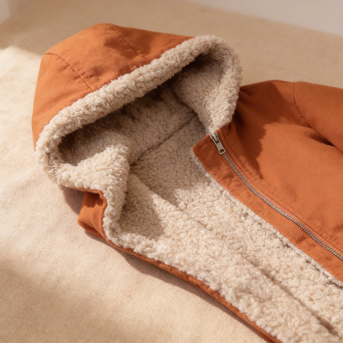 Close detail of the cream curly sherpa lining in the jacket hood and front edge.