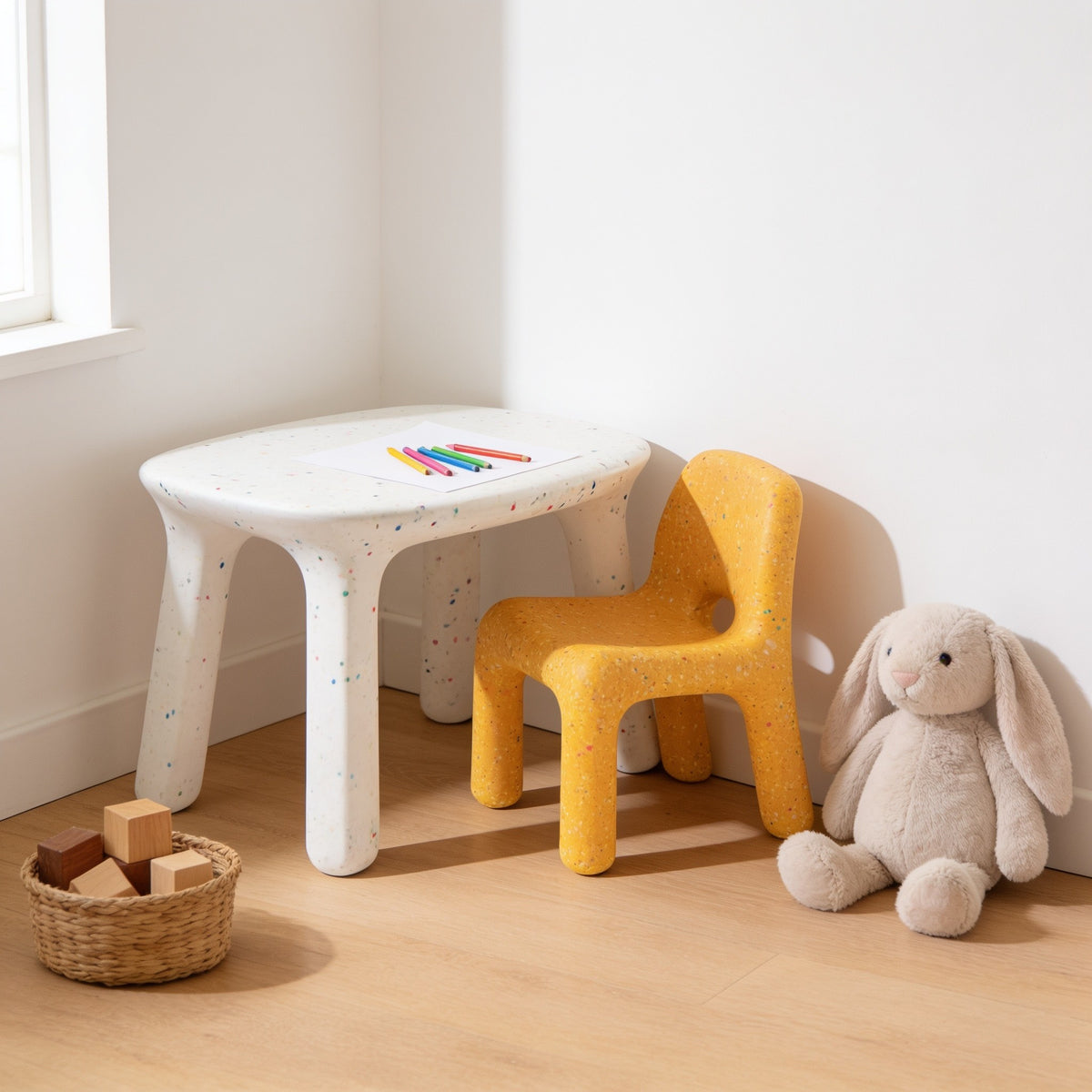 White speckled kids table with yellow speckled chair in a sunny kids room.