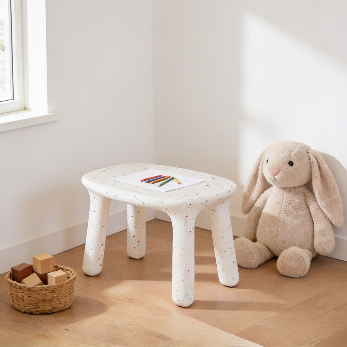 White speckled molded kids table, 75 by 55 cm, 50 cm tall, in a sunny kids room.