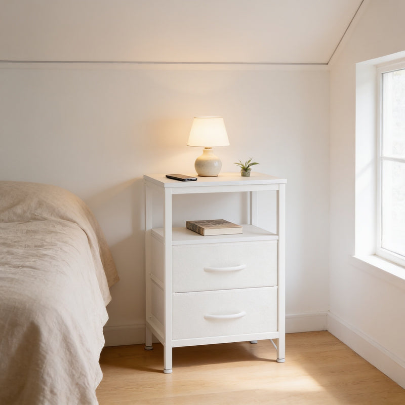 Ivory 2-drawer fabric nightstand with charging station beside a bed, 60 cm tall, lamp and phone on top.