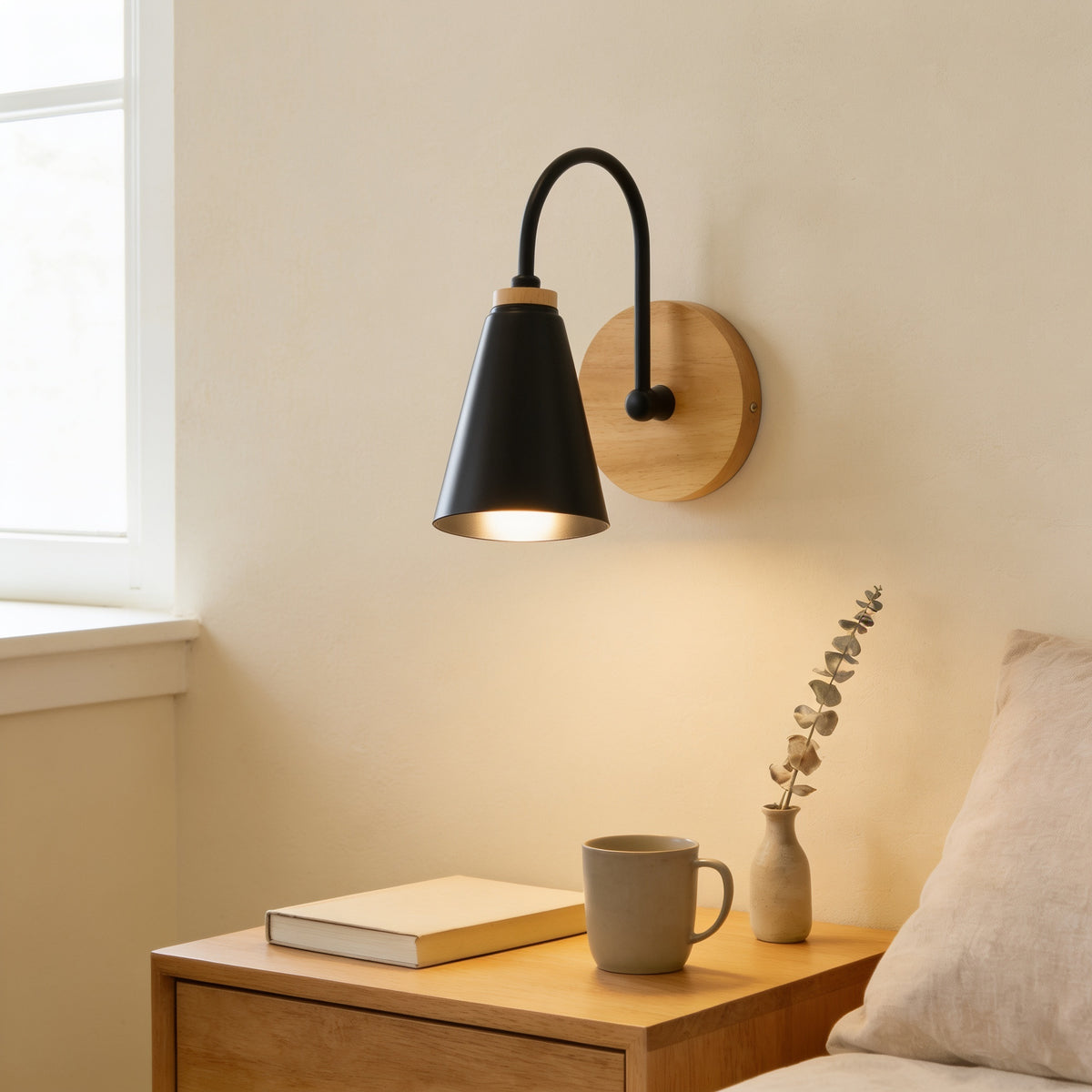 Black cone wall sconce with solid wood base lit warm white above an oak nightstand — Nordic Wood & Metal Cone Wall Sconce