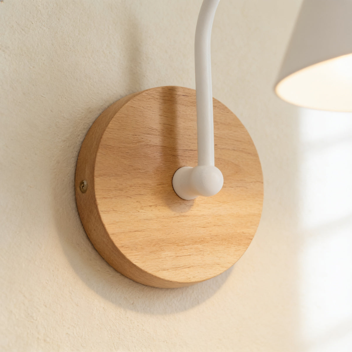 Close-up of the solid wood wall base and white gooseneck arm — Nordic Wood & Metal Cone Wall Sconce